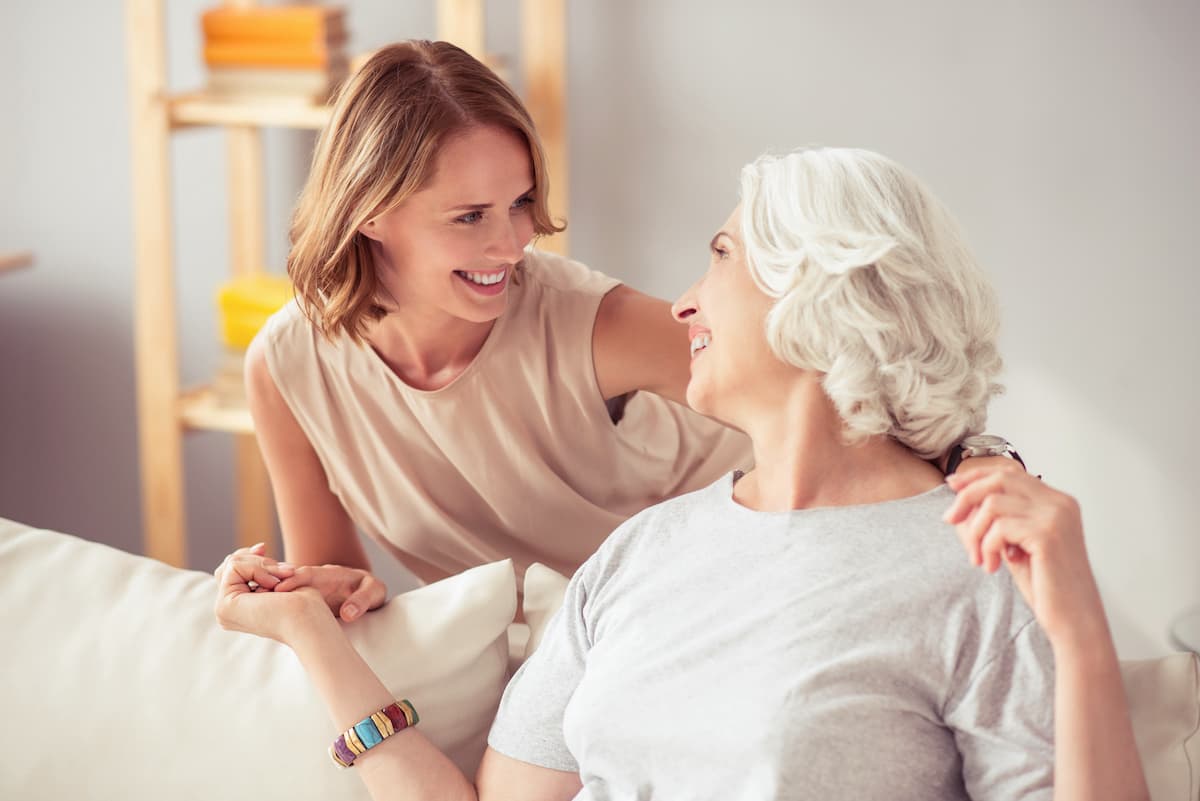 An adult daughter spending time with her elderly mother at home
